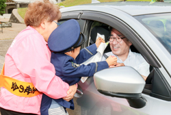 園児が啓発グッズを配って安全運転を呼び掛けた＝27日、出雲市大社町の県立浜山公園