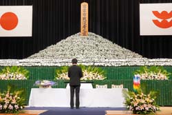 〈写真：ステージに祭壇と献花台が設けられた〉