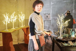 〈写真：「レトロガラスの白いツリー」などが並ぶ会場で、赤尾さん＝22日、ワイナリー奥出雲葡萄園地下ギャラリー〉