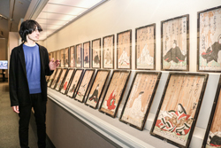 〈写真：１７６３（宝暦13）年の本殿遷宮の際に寄進された「三十六歌仙図額」を紹介する藤原雄高学芸員＝14日、出雲市浜町の出雲文化伝承館〉