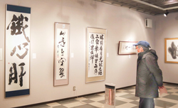 〈写真：額装や軸装された作品が並ぶ＝古代鉄歌謡館ギャラリー〉