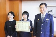 受賞した江⻆さん（中央）。左は江角由利子さん、右は窪田浩仁出雲署長＝８日、出雲市斐川町沖洲の斐川東中
