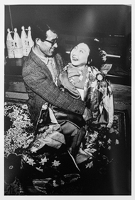 〈写真：胎児性の患者の上村智子さんと父親。成人式の祝いの席（１９７７年）〉