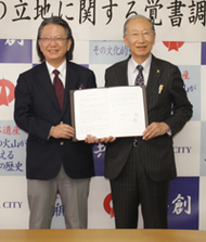 〈写真：覚書を手にする今井書店の達山暢会長（左）と楫野弘和市長＝27日、大田市大田町の大田市役所〉