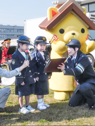 園児が交通安全を呼びかける唱和を行い、関係者が見守った＝３日、松江市殿町の県庁前芝生広場