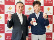 〈写真：激励金の目録を手に竹内専務理事とガッツポーズをする伊藤さん（右）＝８日、松江市上乃木の県立水泳プール〉
