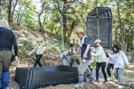 〈写真：伐採木や腐葉土を使い、カブトムシドーム作りに取り組む参加者＝出雲市多久町、大慶寺公園〉