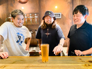 〈写真：オリジナルクラフトビールを前に高橋組合長（中央）＝17日、大田市温泉津町の高橋組合長経営の飲食店〉