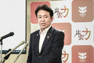 〈写真：大規模火災への対応を説明する飯塚市長＝25日、出雲市今市町の出雲市役所〉