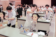 〈写真：ワインディングの競技に挑む参加者たち＝29日、出雲市平田町の平田文化館〉