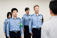 〈写真：熊本地震の被災地での活動を終え、田邨尚之生活安全部長（右手前）に帰県報告する島根県警の派遣部隊員＝12日、松江市殿町の県警本部〉