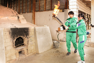 〈写真： 閉校前最後の本焼きに向け、登り窯に火を入れる生徒たち＝18日、大田市水上町の大田市立第三中学校〉