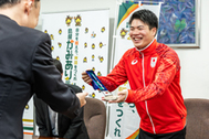 〈写真：笑顔で銀メダルを丸山知事に見せる須山晴貴選手＝27日、松江市殿町の島根県庁〉